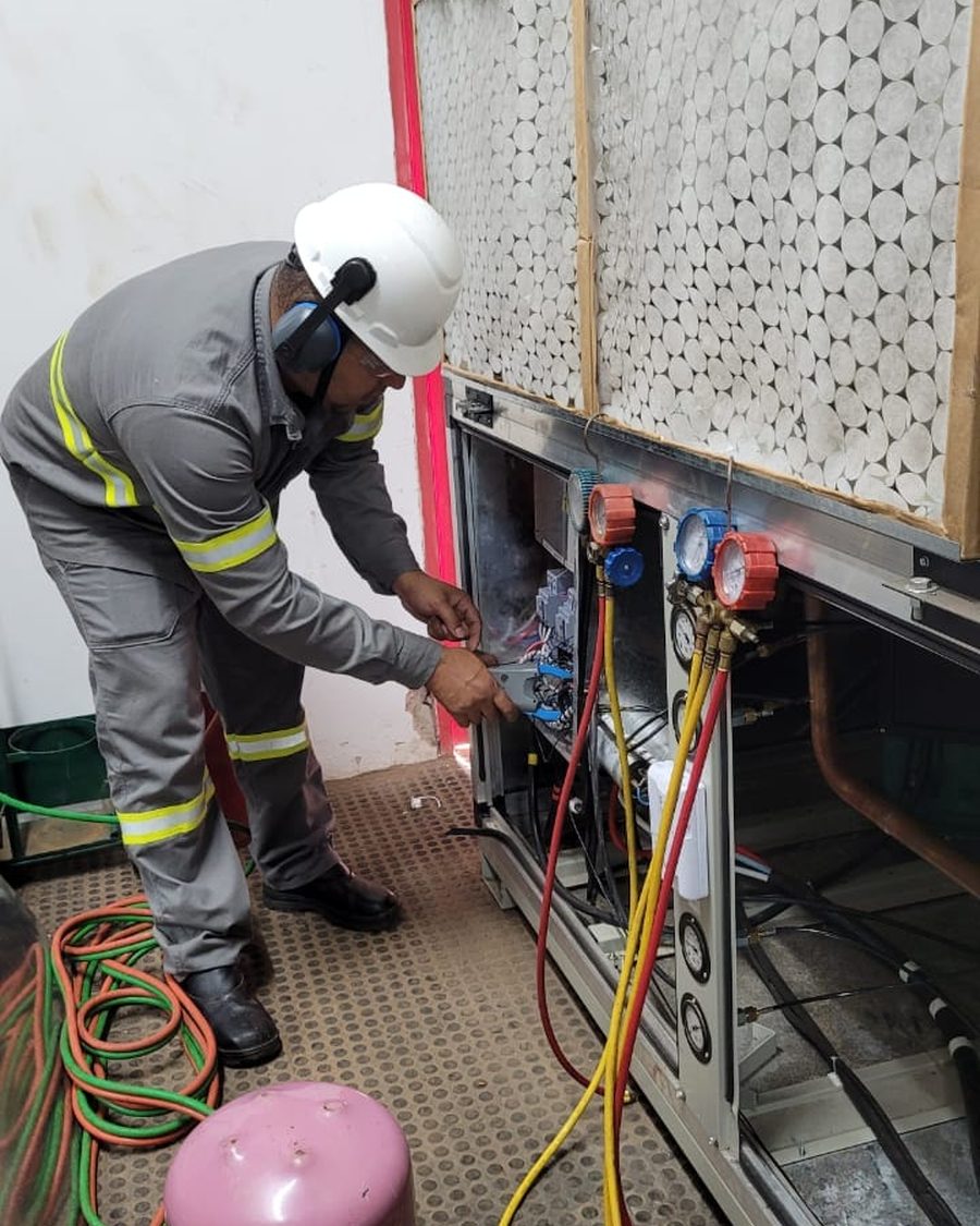 Técnico com manifold em manutenção de unidade industrial
