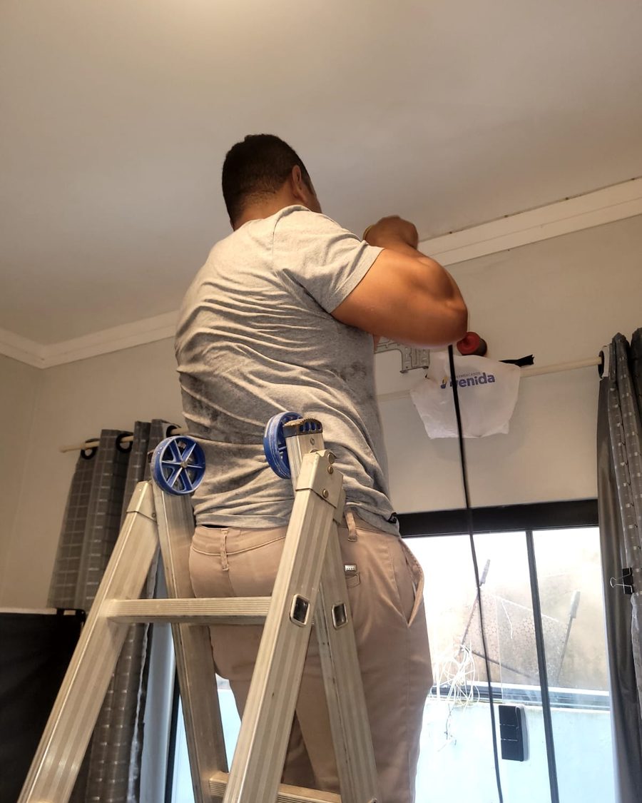 Técnico da D.A. instalando ar-condicionado em ambiente comercial